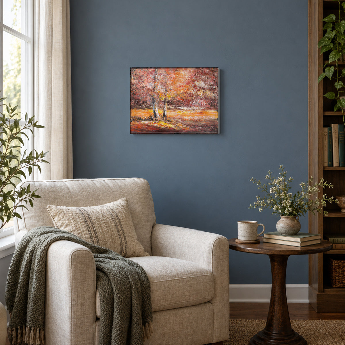 Ember Forest by Yingzhi Chen hanging on a muted slate-blue painted wall above a reading corner with a linen armchair and a small round side table