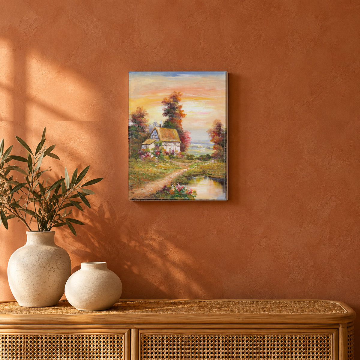 Cottage by the Water by Yingzhi Chen hanging on a terracotta clay limewash wall above a low rattan console with two cream ceramic vases