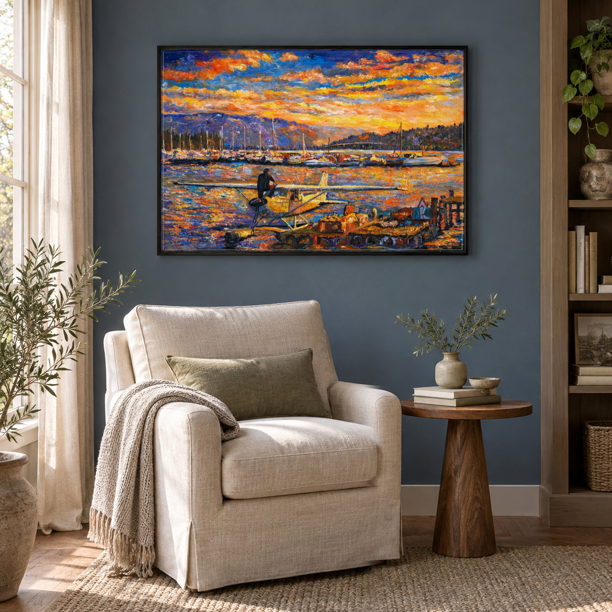 Okanagan Lake, Between Departures by Zhongda Huang hanging on a muted slate-blue painted wall above a reading corner with a linen armchair and a small round side table