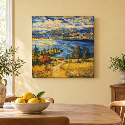 Okanagan Lake from the Heights by Zhongda Huang hanging on a pale butter-yellow plaster wall above a light wood dining table edge with a bowl of lemons