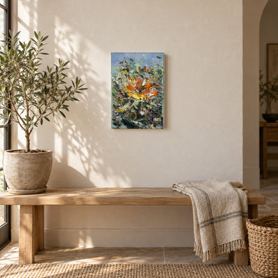 Wild Bloom by Yingzhi Chen hanging on a warm off-white plaster wall above a light oak bench with a folded linen throw and a potted olive tree